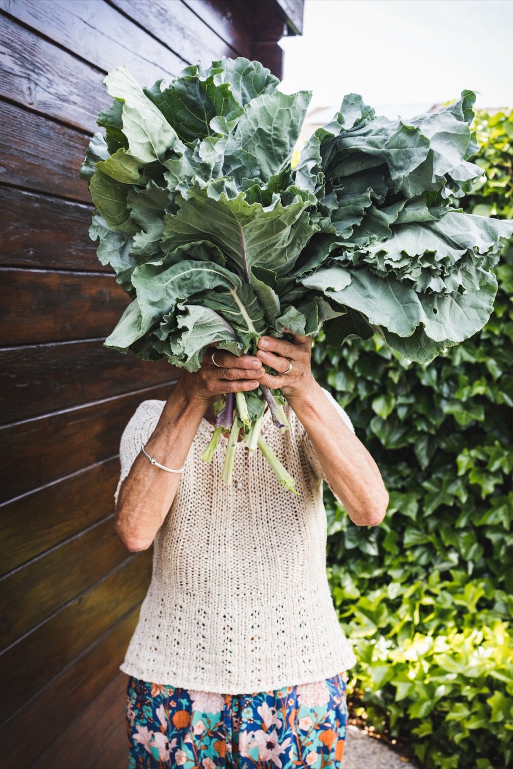 Woman harvesting greens from an Edible Balconies vertical garden